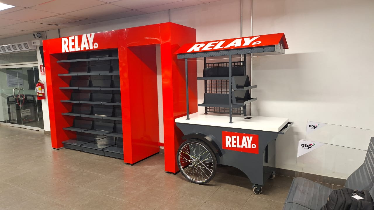Red-and-black backwall, shelving and impulse cart for a regional airport retail location
